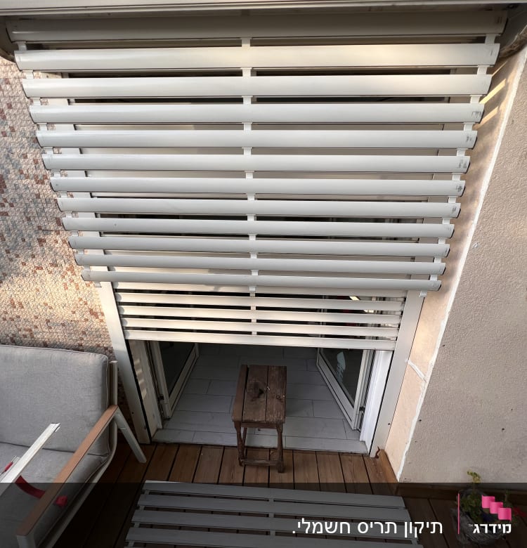 תריסים לבנים פתוחים למחצה עם שלב שבור על הרצפה